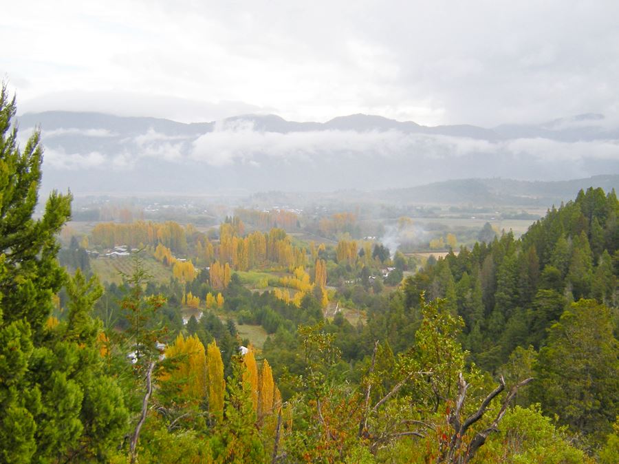 El Hoyo visto desde la Cascada, bosque, montañas y un valle agricola en una tarde nubosa de otoño
