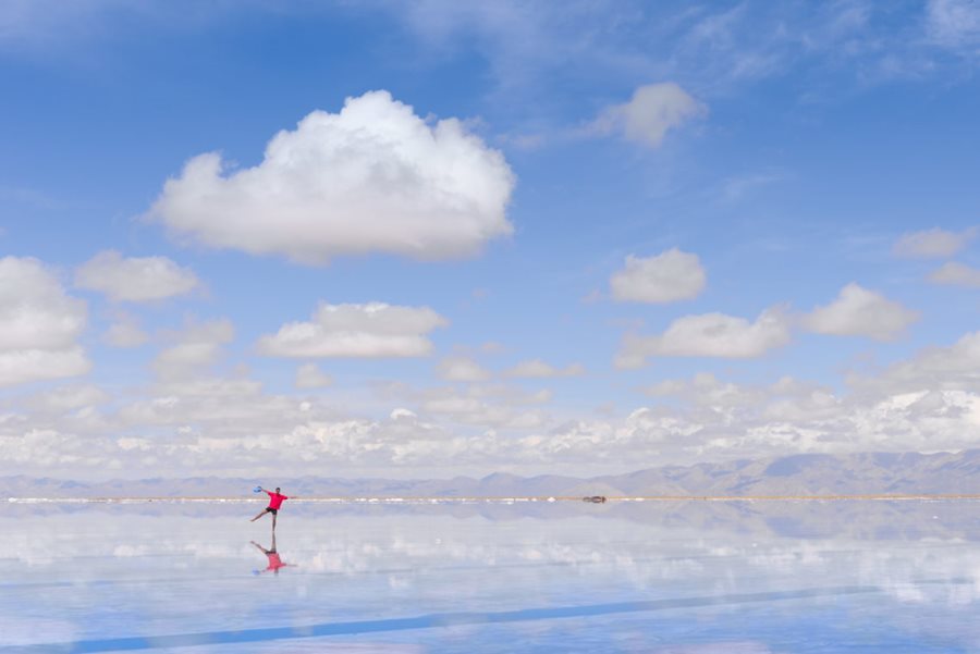 Water over the salt flats and man standing on it