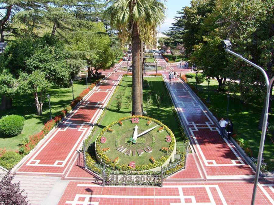 reloj en la plaza enorme reloj en la arbolada plaza, formado con césped y flores