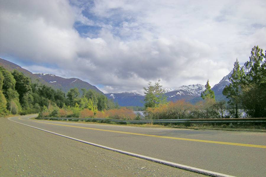 The road, forests, mountains and the blue lake at Kilómetro 2019 post of Ruta 40 at Lake Gutiérrez in Patagonia