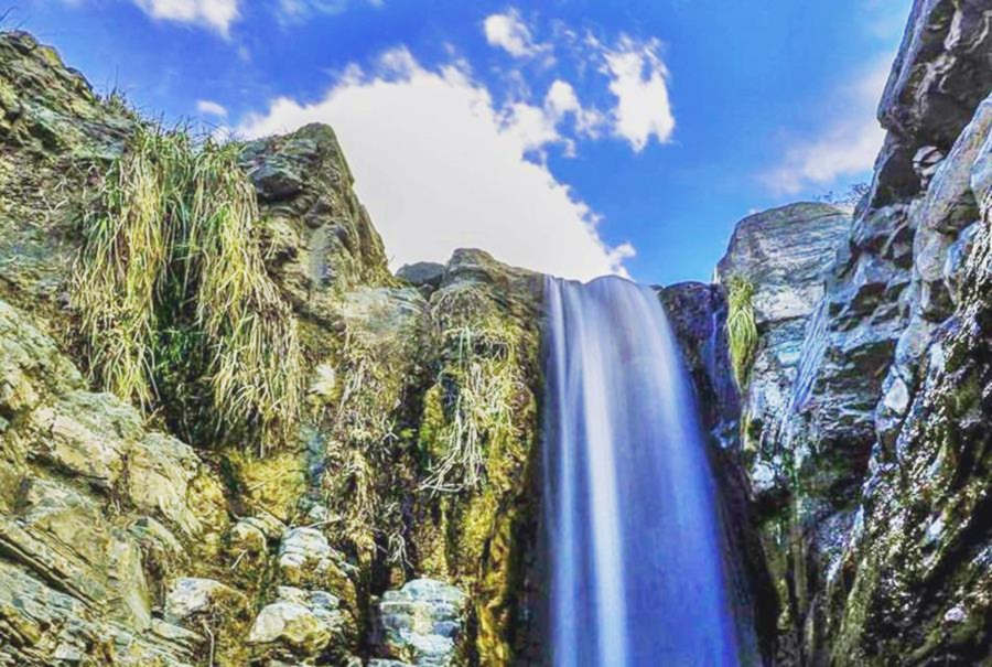 cascada cayendo en la pared de rocas